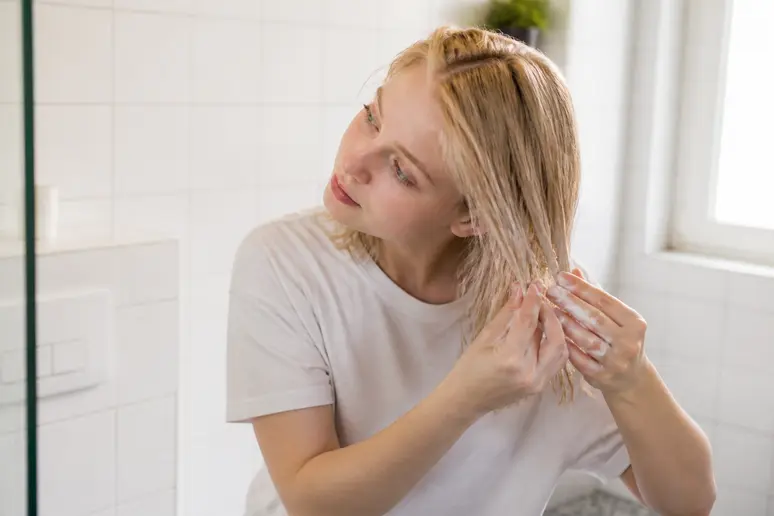 Jeune femme appliquant le cut by fred masque avec soin sur cheveux fins pour éviter l'alourdissement.