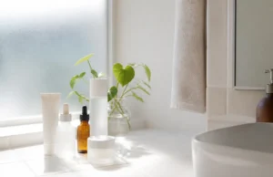 Nacomi avis : sérums Next Level, composition INCI et SPF Plusieurs flacons de cosmétiques et une protection solaire posés sur un meuble de salle de bain lumineux pour un Nacomi avis.