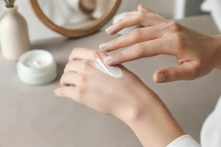 Geste d'application d'une crème hydratante pour le visage sur la peau