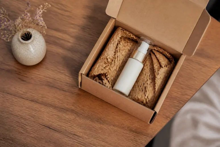 Colis de livraison de cosmétiques ouvert sur un bureau en bois clair