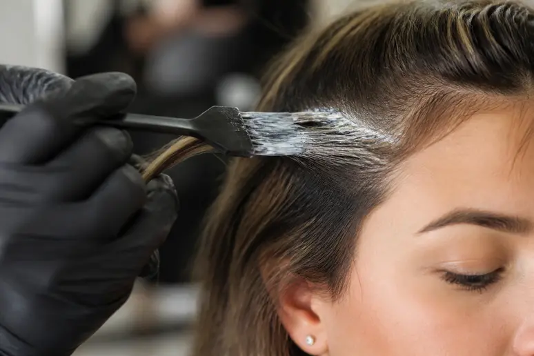 Application minutieuse du produit de décoloration sur les baby hair pour réaliser la scandi hairline