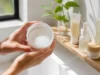 Toner pads coréens : niacinamide, centella, glutathione Un pot ouvert rempli de toner pads posé sur une étagère en bois dans une salle de bain lumineuse