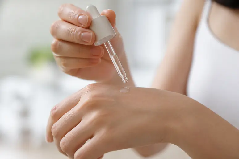 Test d'application d'une goutte de sérum hydratant Topicrem sur le dos de la main.
