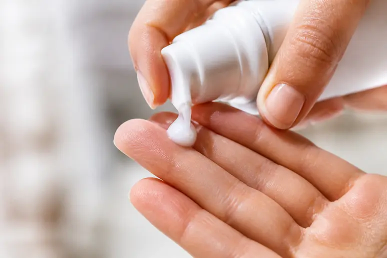 Application d'une crème fluide hydratante pour structurer sa routine de soin minimaliste