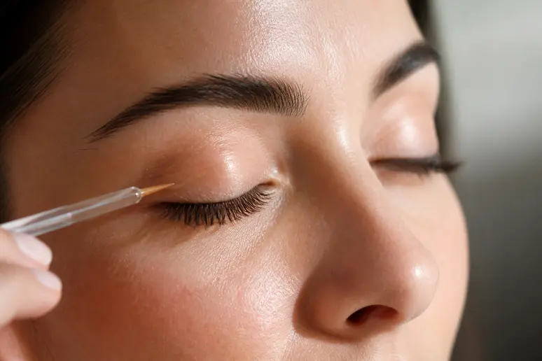 Application minutieuse du sérum Maholash le long de la frange ciliaire supérieure