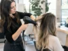 AirTouch ou balayage classique : lequel choisir ? Un coiffeur réalise un airtouch balayage minutieux dans un salon lumineux