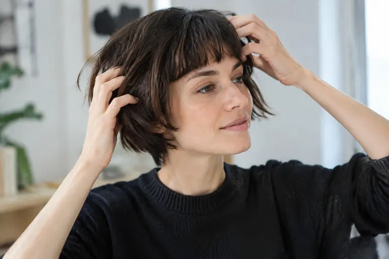 Mains coiffant souplement un french bob coupe pour conserver un mouvement naturel