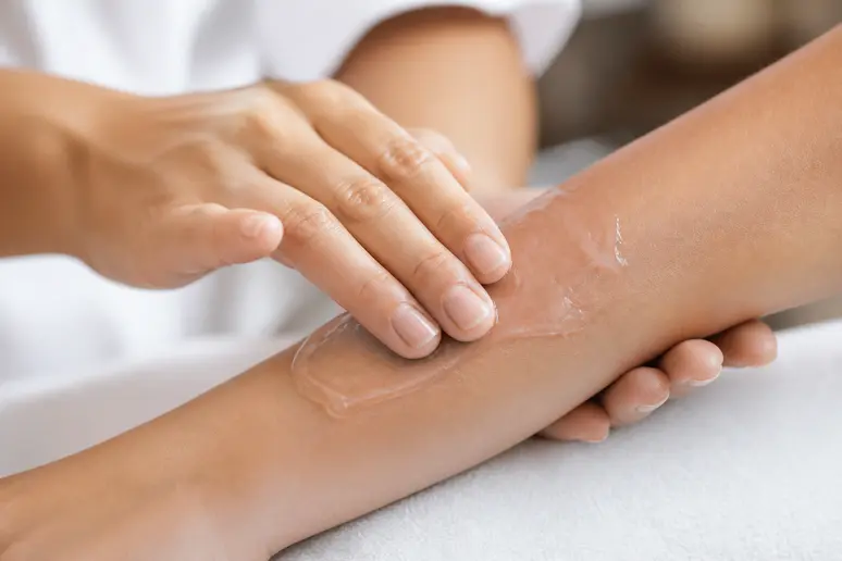 Application d'un gel conducteur sur la peau pour préparer une séance de soins anti-rides